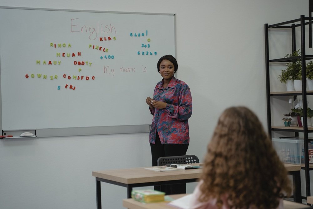 Teacher conducting an English class at a whiteboard
