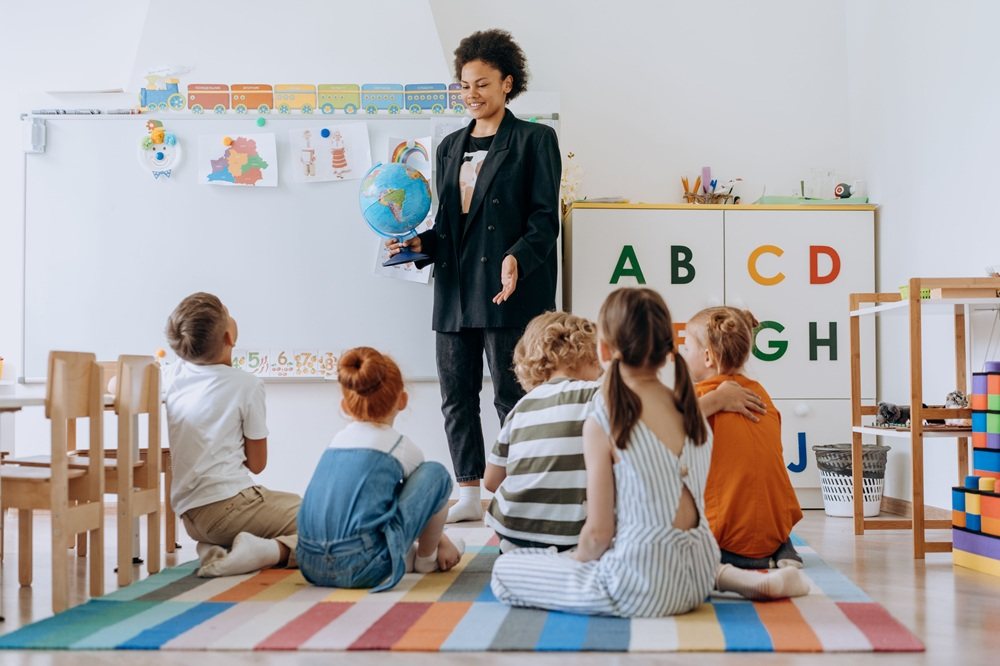 Pre-primary teacher with children sitting on a rug